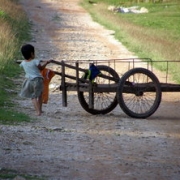 Girl pushing pushcart on gravel road, Travel alone as a woman